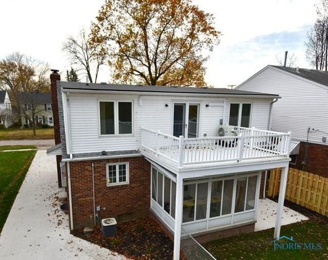 back of property with a balcony and a sunroom