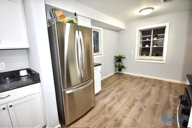 kitchen with white cabinetry, light hardwood / wood-style floors, and appliances with stainless steel finishes