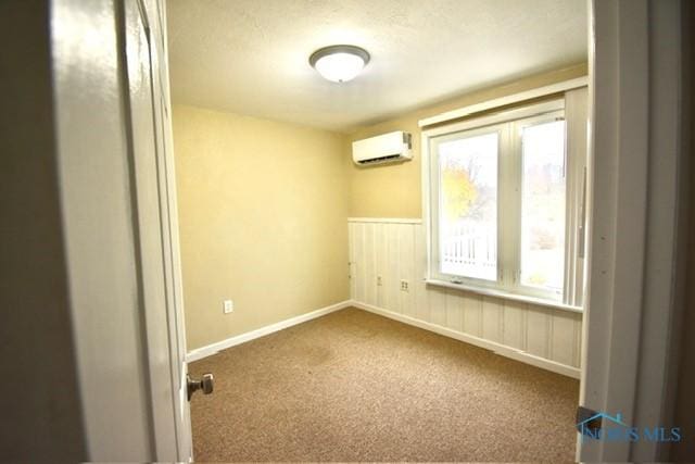 carpeted spare room featuring a wall mounted AC