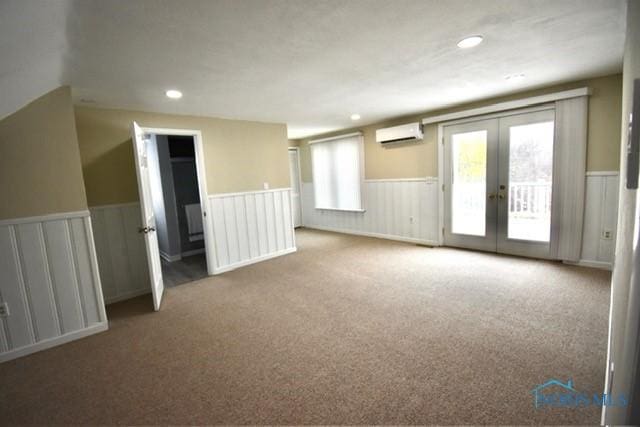 interior space with french doors, a wall unit AC, and plenty of natural light