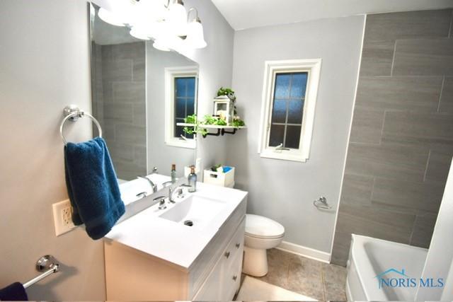 bathroom featuring a bathing tub, vanity, and toilet