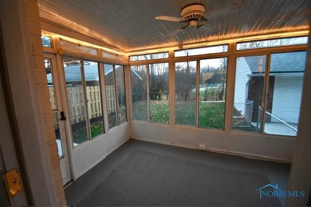 unfurnished sunroom with ceiling fan