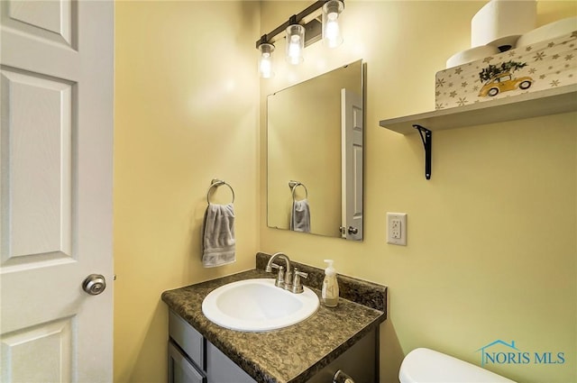 bathroom featuring vanity and toilet