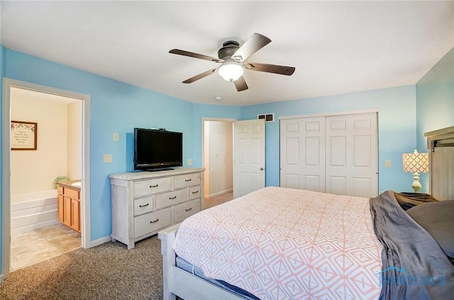 carpeted bedroom with ceiling fan, a closet, and ensuite bathroom