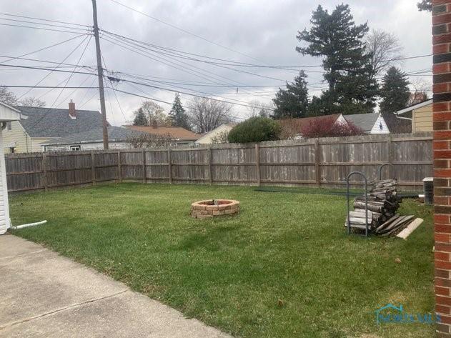 view of yard with an outdoor fire pit and central AC