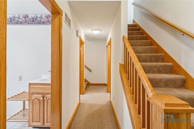 hallway featuring light colored carpet