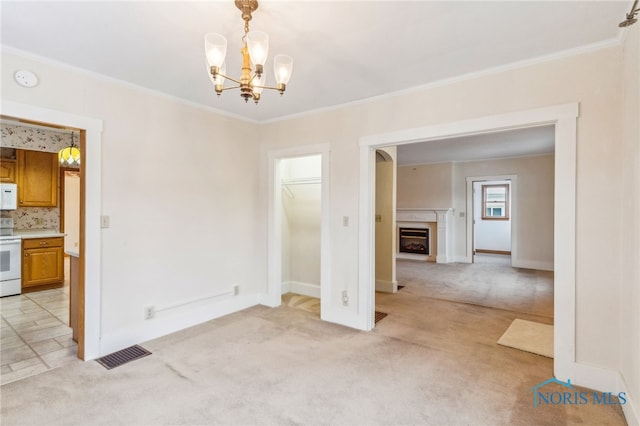 interior space featuring light carpet, a chandelier, and ornamental molding