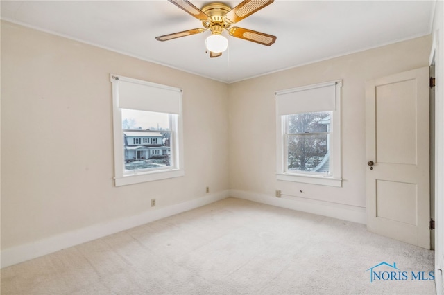 carpeted empty room with a wealth of natural light and ceiling fan