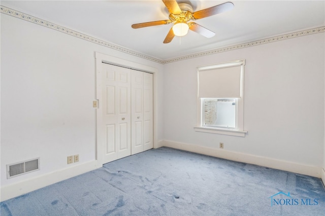 unfurnished bedroom featuring carpet, a closet, and ceiling fan