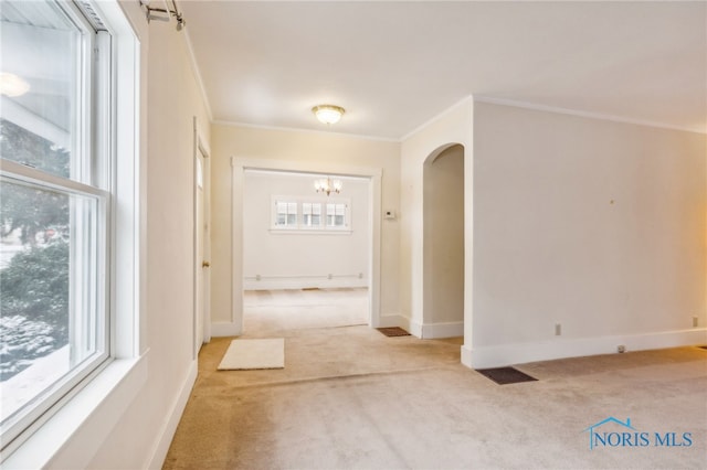 hall with ornamental molding and light carpet