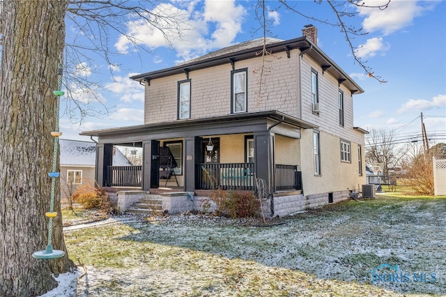 view of front facade featuring covered porch, central air condition unit, and a front lawn