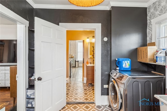 clothes washing area with washer / clothes dryer and crown molding