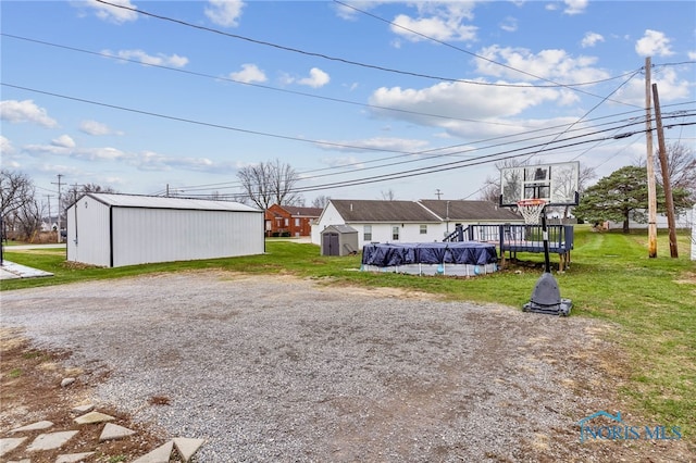 view of property exterior with a swimming pool side deck, a yard, and a storage shed