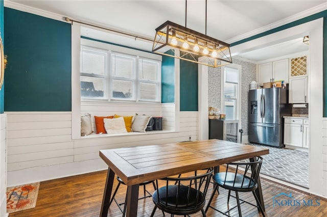 dining room with dark hardwood / wood-style flooring and crown molding