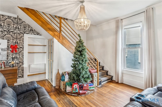 living room with hardwood / wood-style floors, crown molding, and a notable chandelier