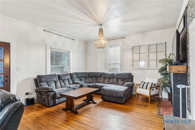 living room with a chandelier, hardwood / wood-style flooring, and ornamental molding