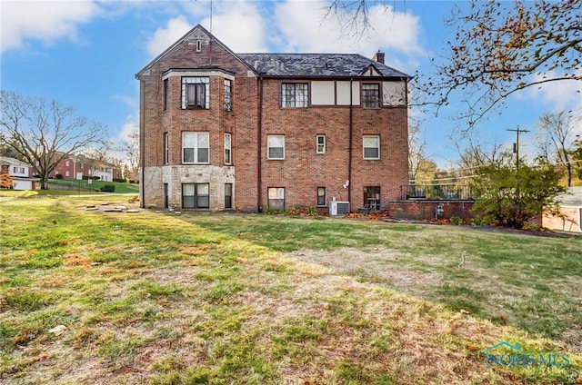 rear view of house with a yard and central AC unit