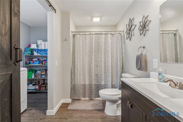 bathroom with hardwood / wood-style floors, vanity, toilet, and walk in shower