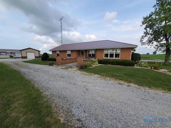 single story home with an outbuilding, a front yard, and a garage