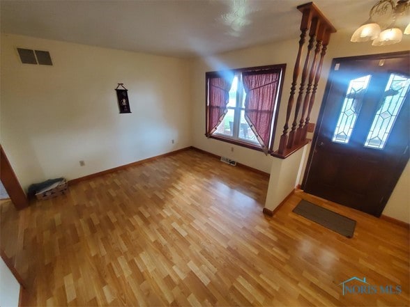 entryway featuring wood-type flooring and a notable chandelier