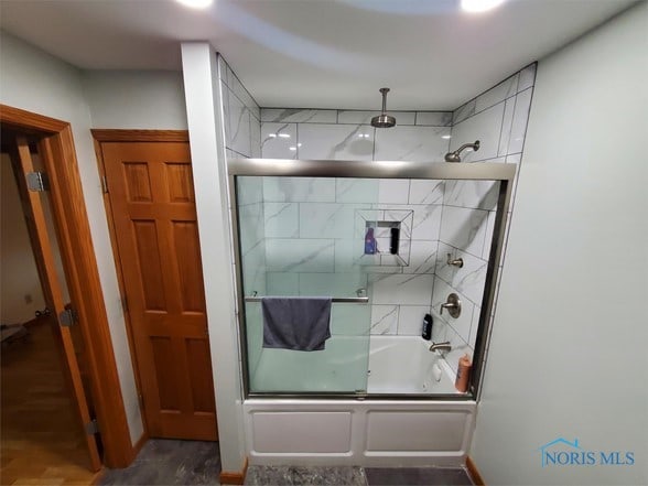 bathroom with shower / bath combination with glass door