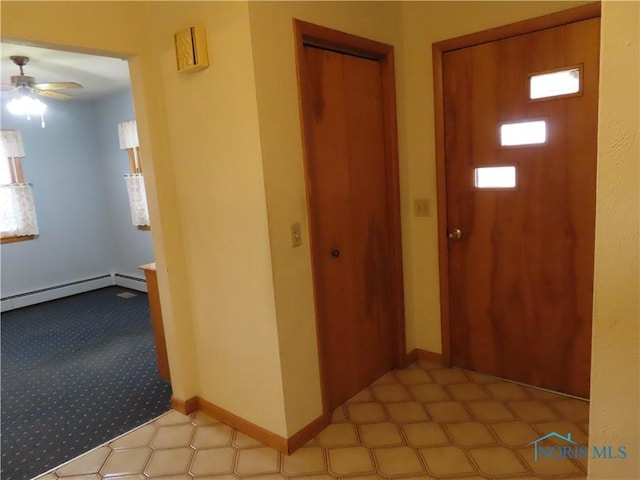 entrance foyer with baseboard heating and ceiling fan