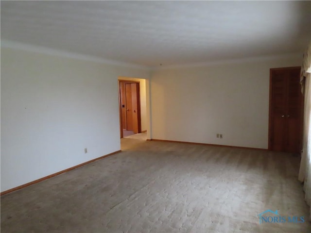 unfurnished room featuring light carpet