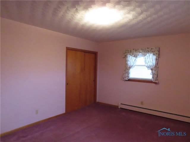 unfurnished bedroom featuring carpet, a closet, and baseboard heating