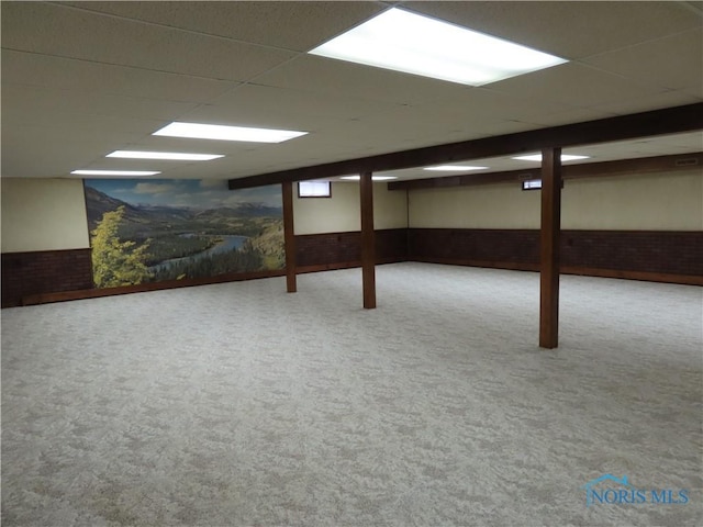 basement featuring a drop ceiling and carpet