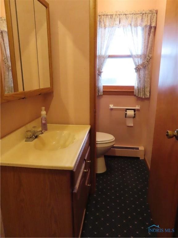 bathroom with vanity, toilet, and baseboard heating