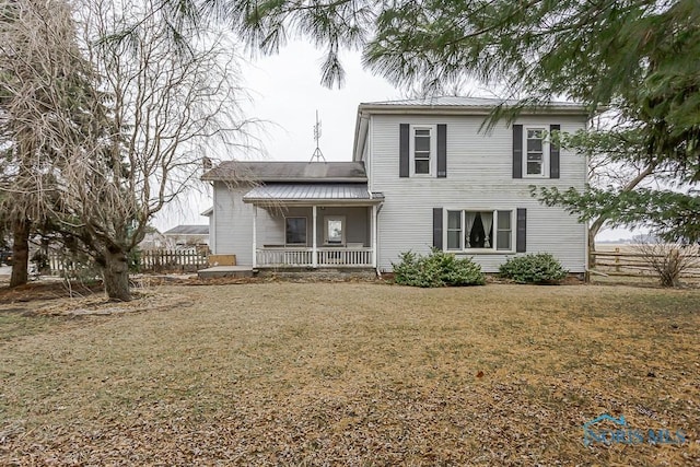 rear view of house featuring a porch and a lawn