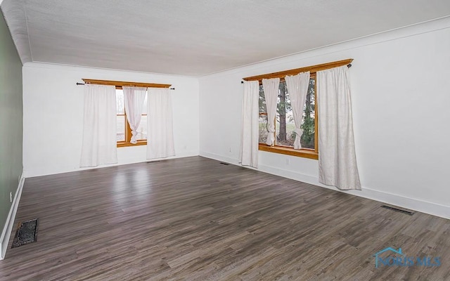 spare room with dark hardwood / wood-style flooring and ornamental molding