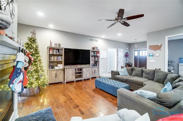 living room featuring hardwood / wood-style floors and ceiling fan