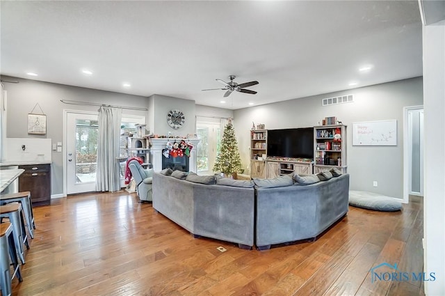 living room featuring light hardwood / wood-style floors, plenty of natural light, and ceiling fan