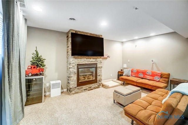 carpeted living room featuring a stone fireplace