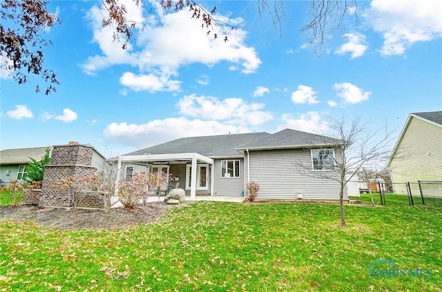 rear view of house featuring a yard and a patio area