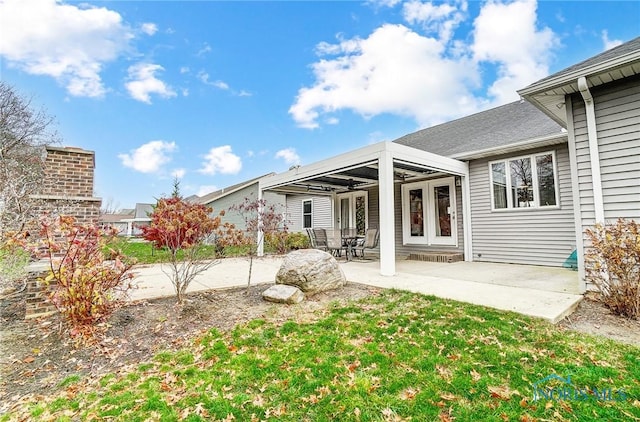 back of house with a yard, a fireplace, and a patio