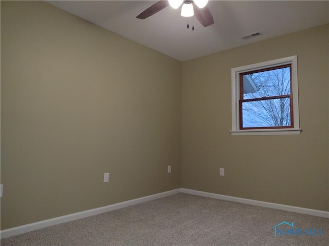 carpeted spare room featuring ceiling fan