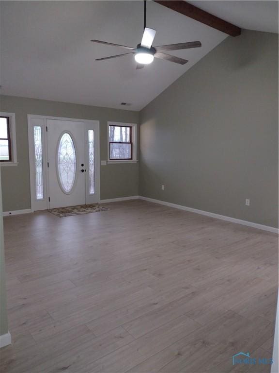 foyer entrance featuring vaulted ceiling with beams, a healthy amount of sunlight, and light hardwood / wood-style floors