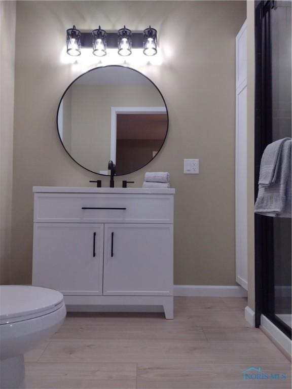 bathroom featuring toilet, vanity, and hardwood / wood-style flooring