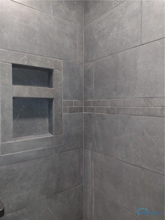 interior details featuring tiled shower