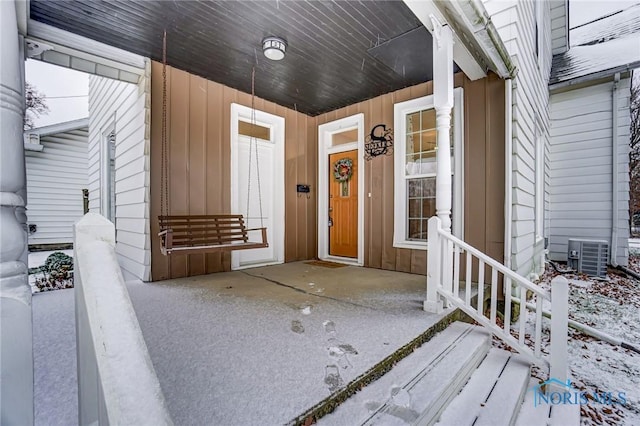 view of exterior entry featuring a porch and central air condition unit