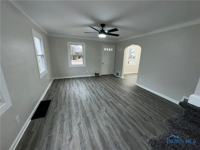 unfurnished living room with ceiling fan, dark hardwood / wood-style flooring, and crown molding