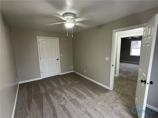 interior space featuring dark colored carpet and ceiling fan