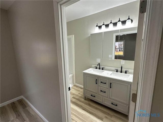 bathroom featuring wood-type flooring, vanity, and a bathtub