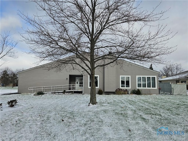 snow covered rear of property with a lawn