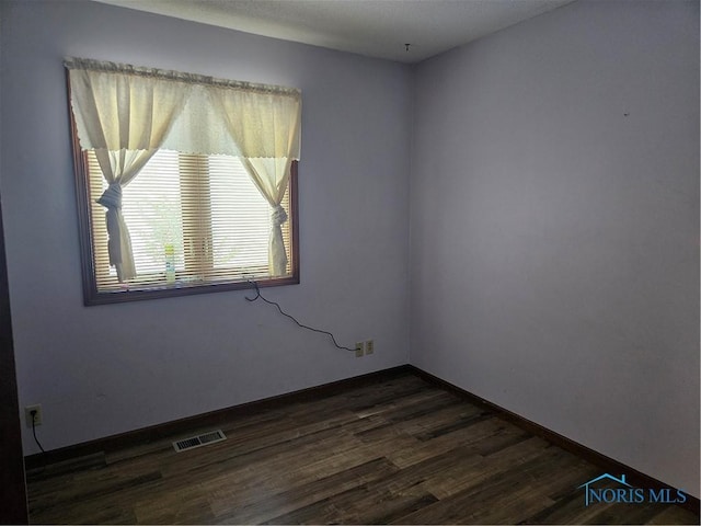 unfurnished room with dark hardwood / wood-style floors