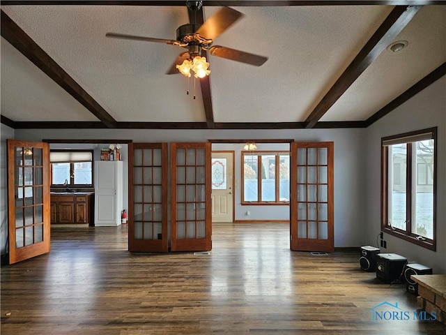 unfurnished living room with a wealth of natural light, french doors, and a textured ceiling