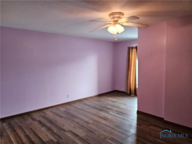 empty room featuring ceiling fan and dark wood-type flooring