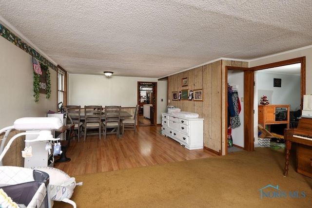 dining area with crown molding, a textured ceiling, and hardwood / wood-style flooring